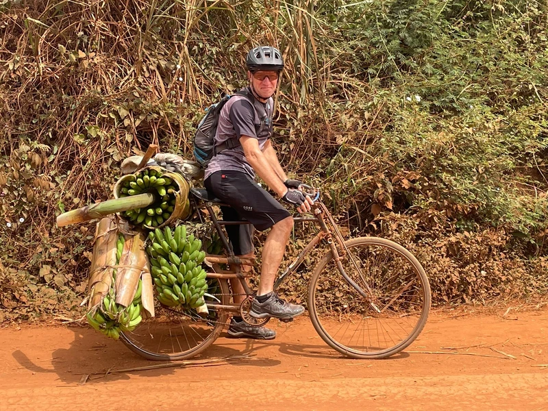 René Horber, Unterstützer der Life Cyclers Uganda, auf einem traditionellen ugandischen Velo mit Bananen beladen. 